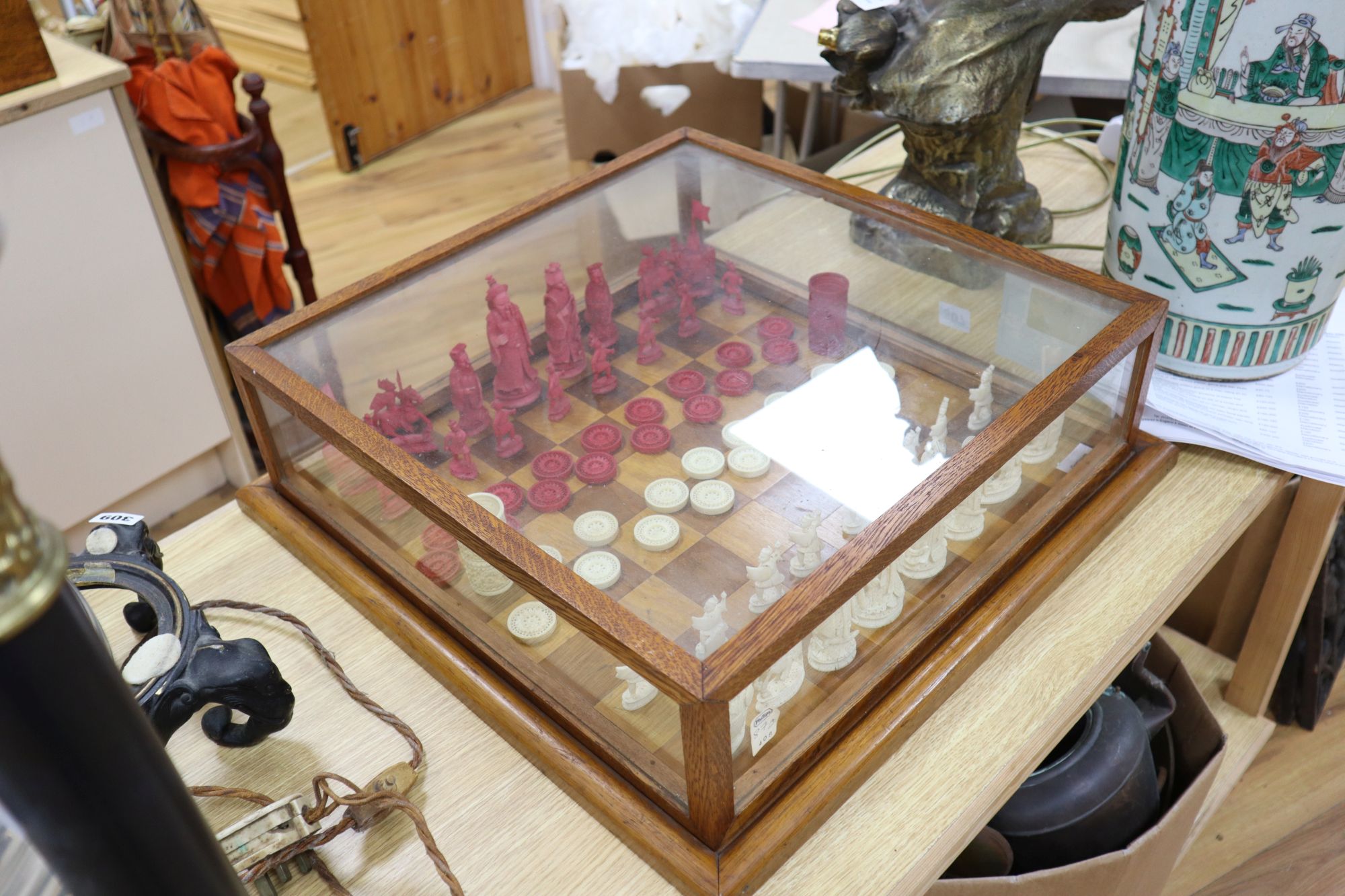 A 19th century Cantonese ivory chess and draught set, with later wood chess board and display cabinet